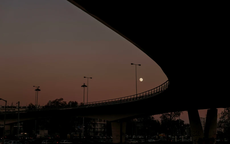 the sky is very clear as cars drive under a bridge