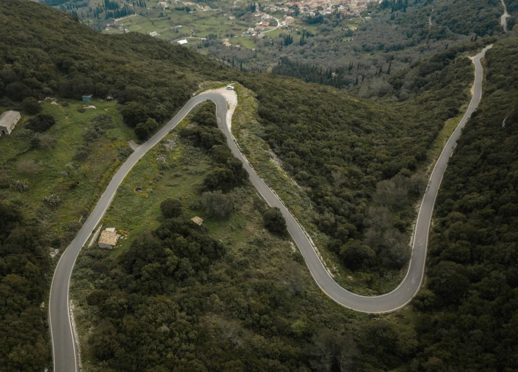 a winding road surrounded by green mountains