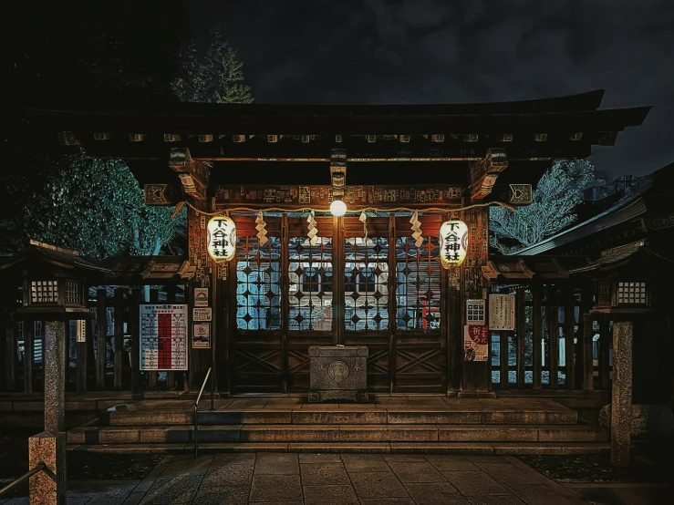 a japanese shrine with lanterns lit up outside