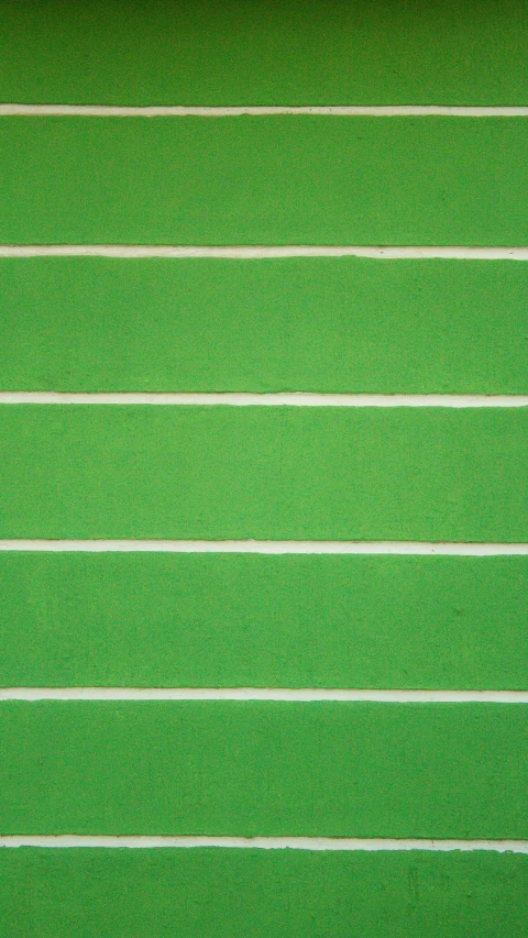 an overhead view of a green turf field with a line of lines in it