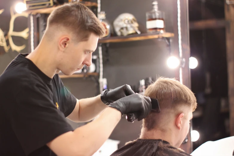 a man in an auto shop  another mans hair