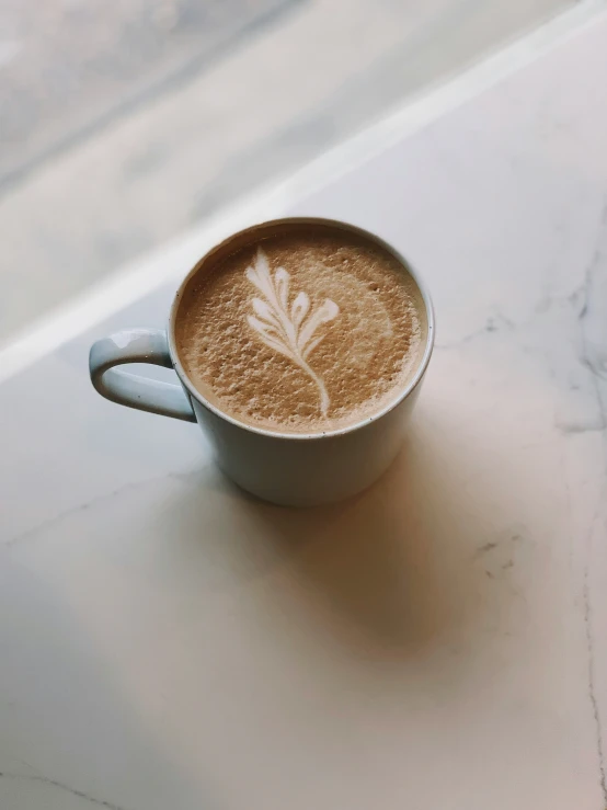 a cup of coffee with some white decoration on it