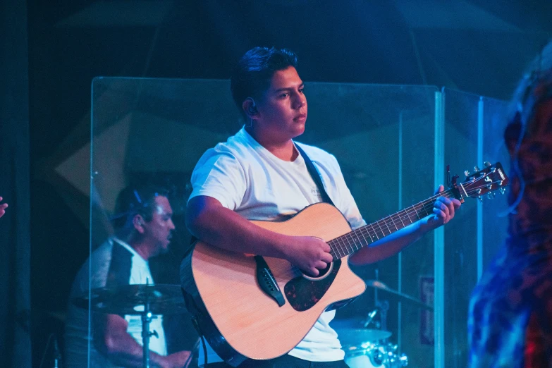 man playing guitar at night in a dark room