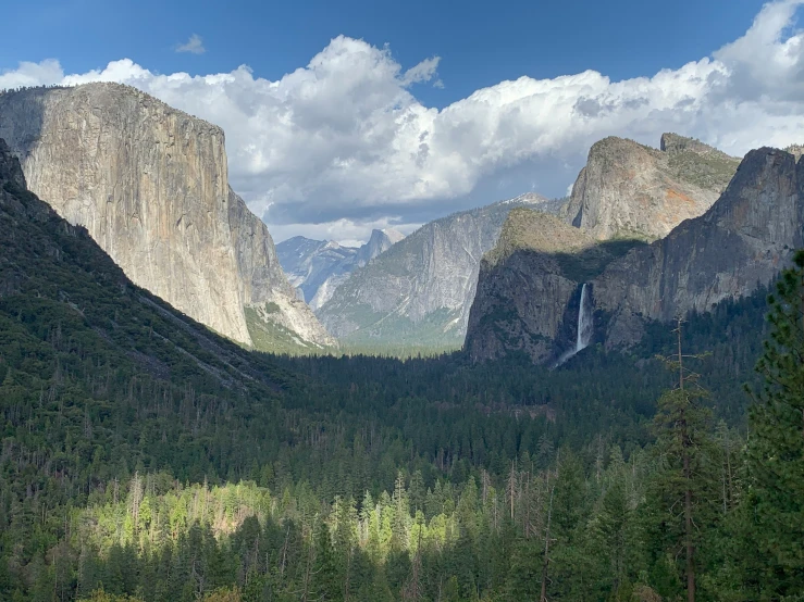 the mountains are tall and the trees are on both sides