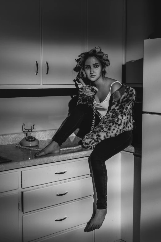 a woman sitting on top of a kitchen counter