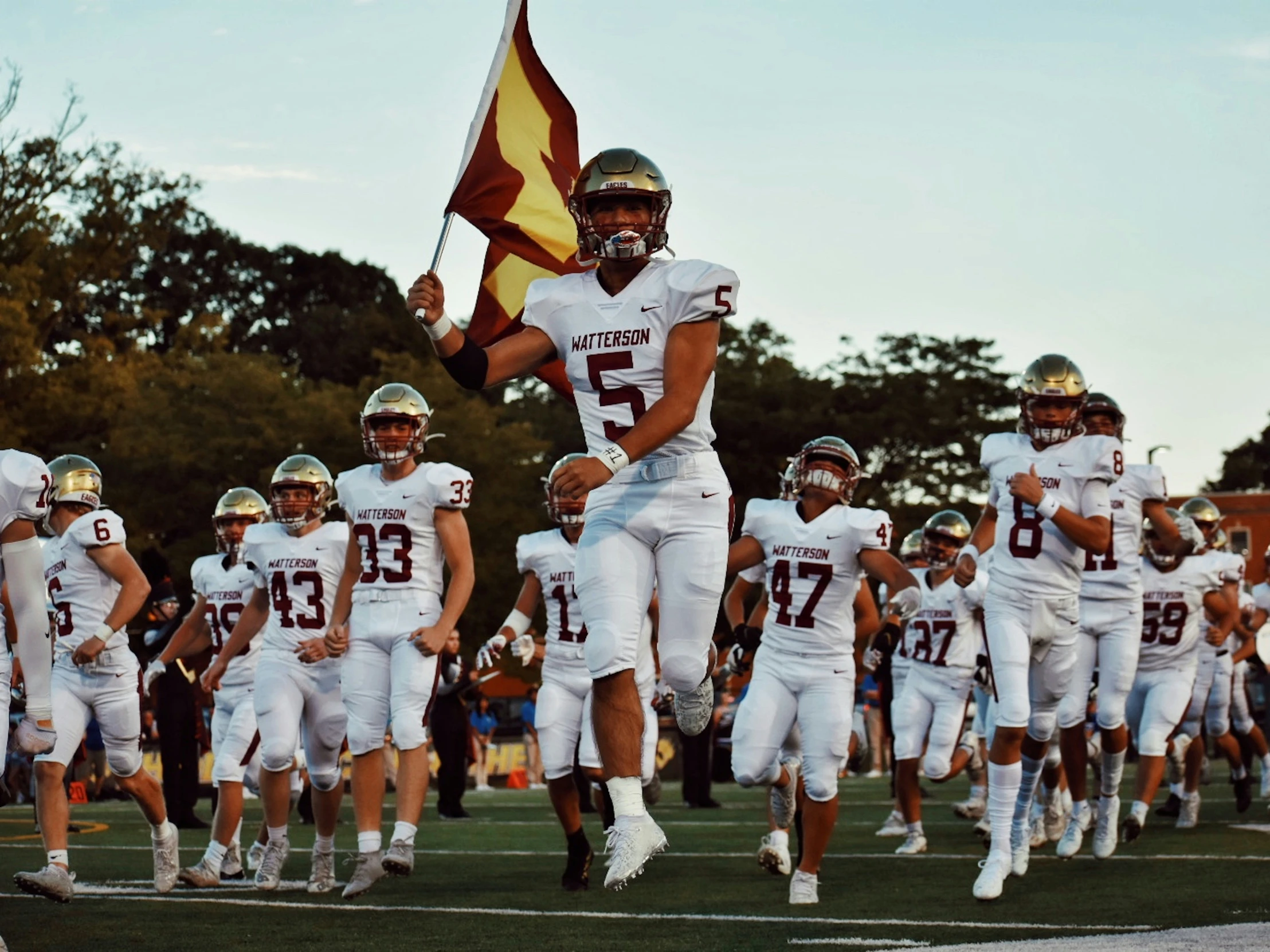 players from the football team run onto the field