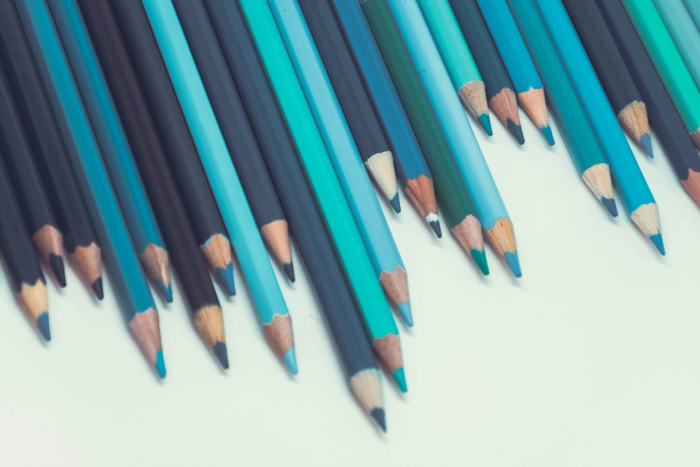 a bunch of blue pencils lined up on a table