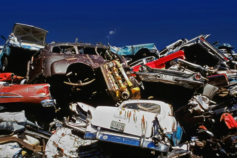 many old cars stacked up together in pile