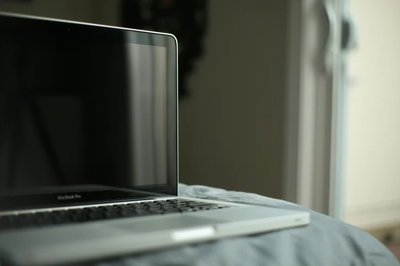 the laptop is on the bed, still in use