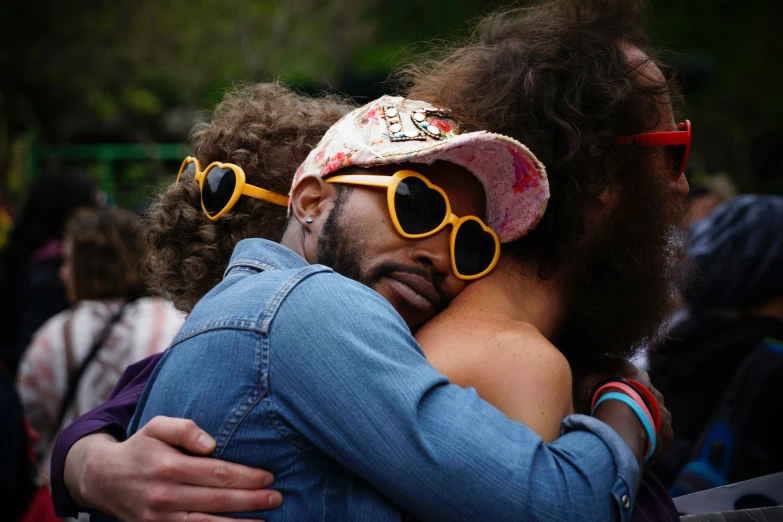 man with afro hair wearing glasses hugs woman