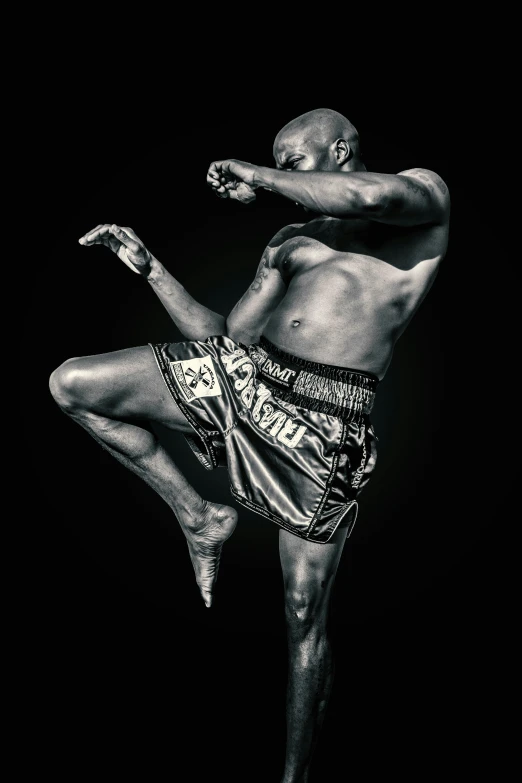 two muaybuks kickbox against a black background