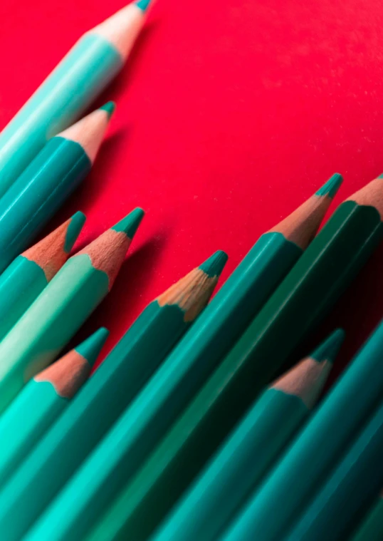 several green and red pencils on a red surface