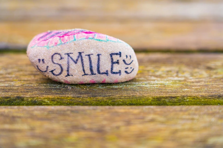 a rock with the words smile on it