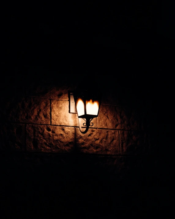 a street light in a darkened area on the side of a wall