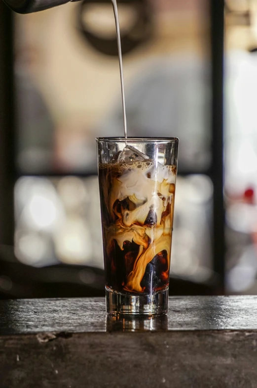 an orange drink being poured into a glass