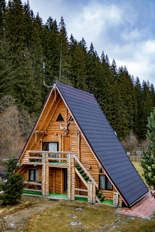 an outdoor log house in front of a forest