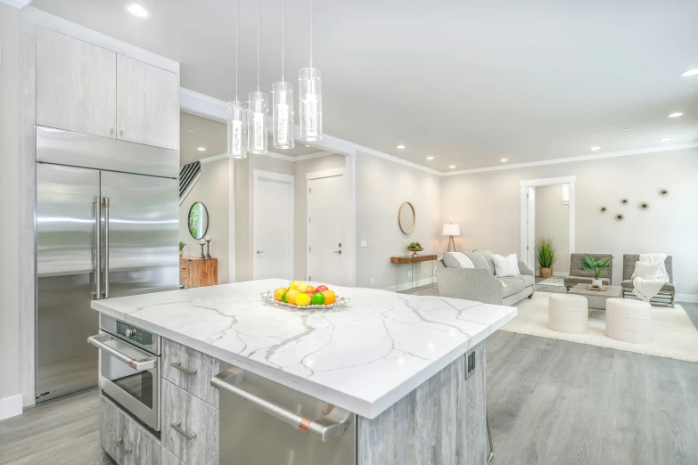 a modern kitchen with marble countertops, silver refrigerator and metallic appliances