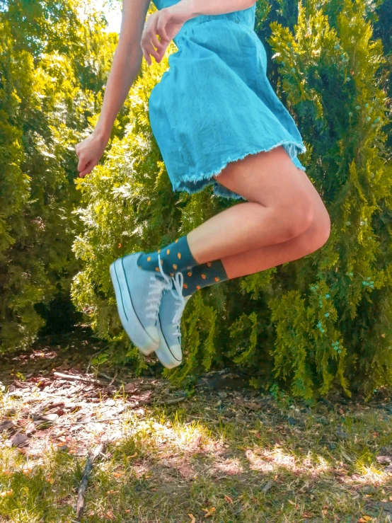 a girl in blue shoes jumping in the air
