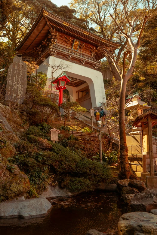 an asian building in the mountains near a creek