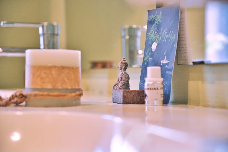 bottles and candles sit in the bathroom sink