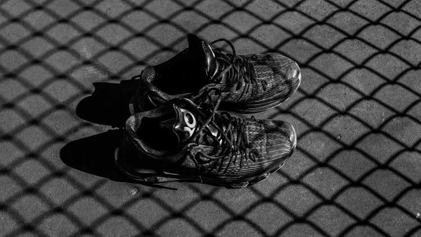 two shoes sit on a street, one with the shadow off