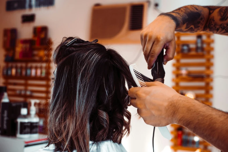 man getting hair cut at barber shop with customer holding scissors