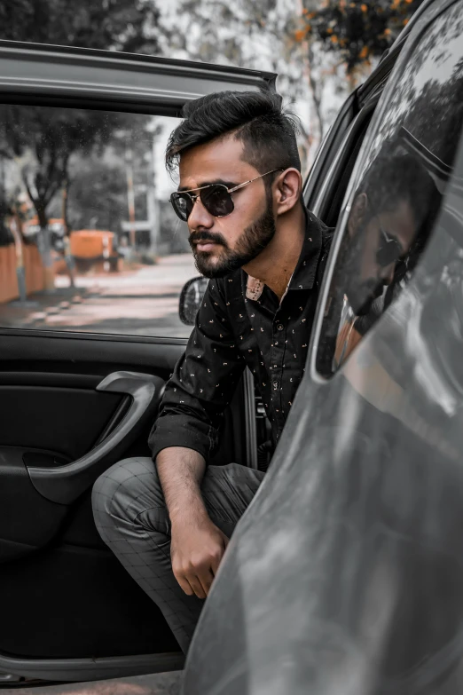 a man standing inside of a car looking at his side window