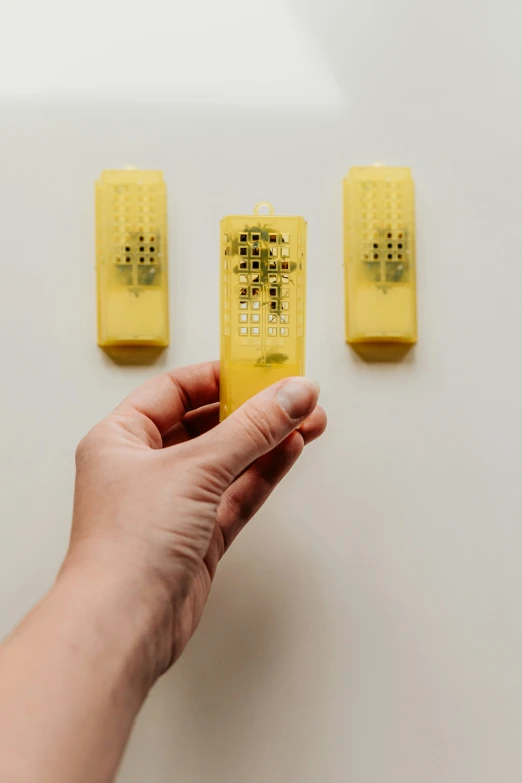 person holding a yellow object next to another small yellow thing