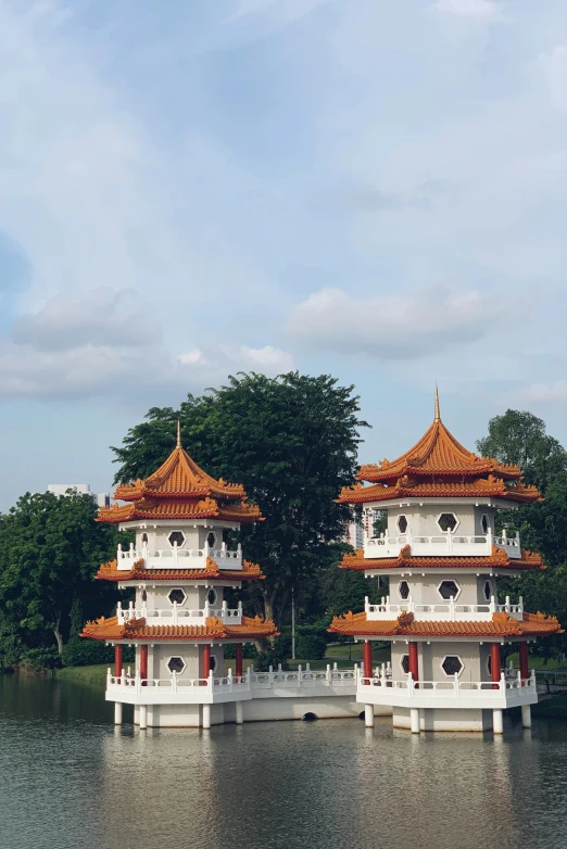 two beautiful, white and red asian structures are reflected in the water