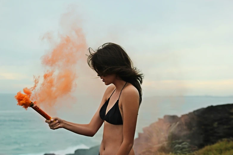 a woman in a bikini holds a lava wand