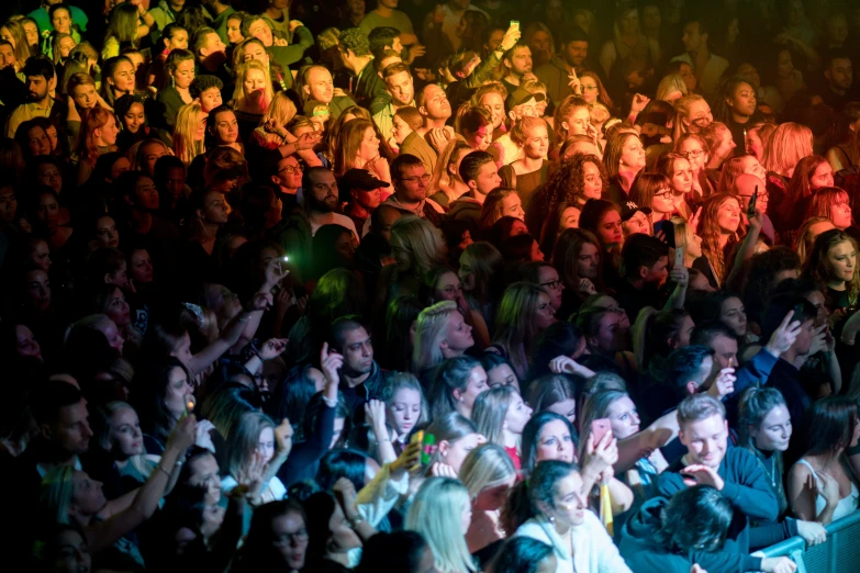 a large crowd watches a concert in the dark
