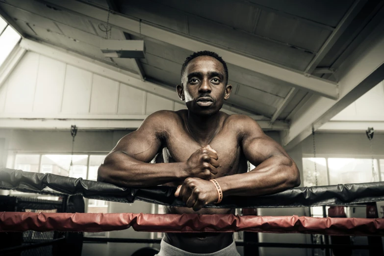 a man poses for a picture in a boxing ring