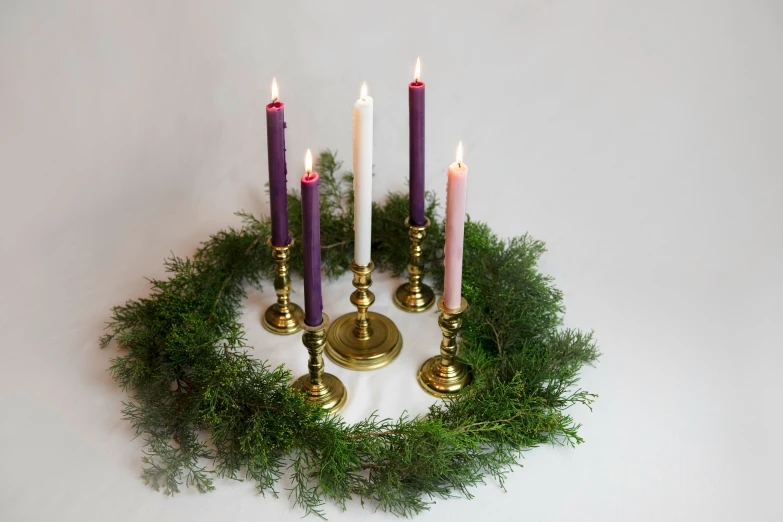 a wreath made with four candles and a single candle