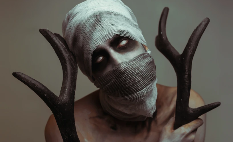 a man in a cloth face mask and antlers