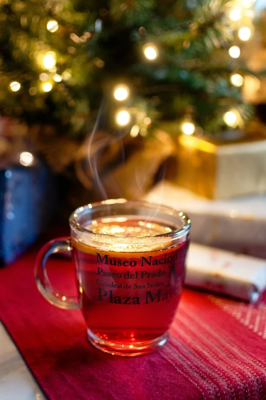 cup of tea with steam rising out of it and the top of a tree behind