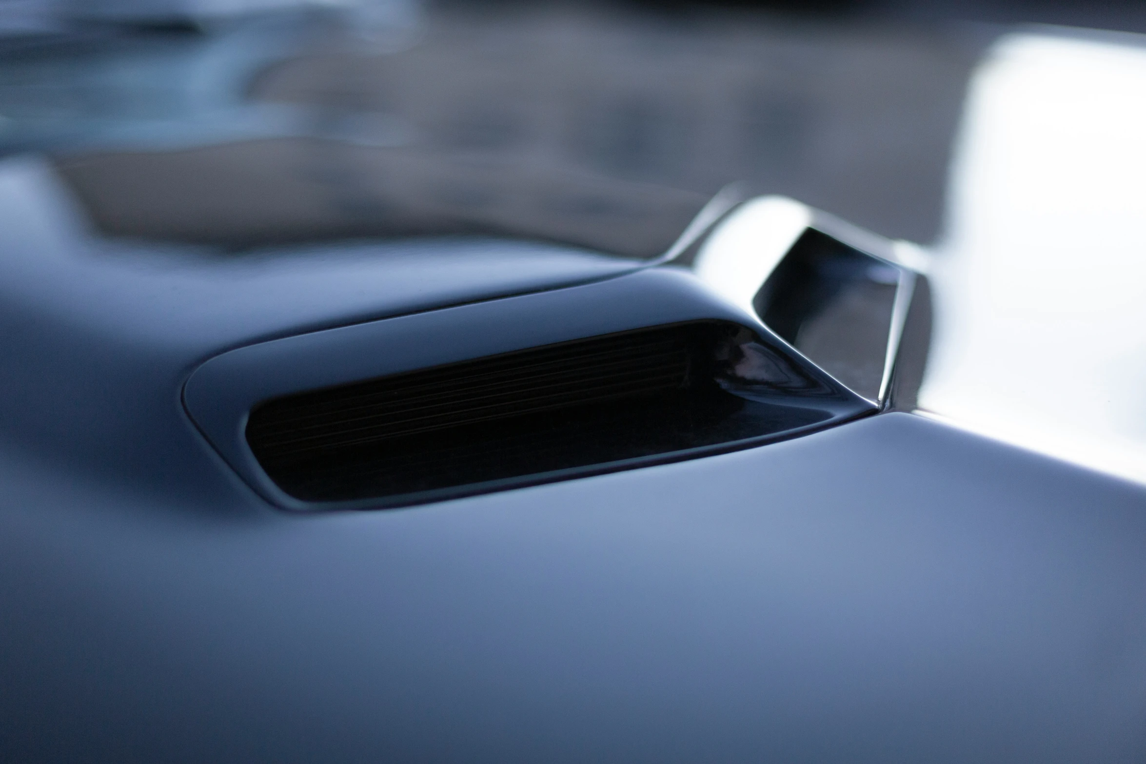 a close up of a small blue car in a parking lot