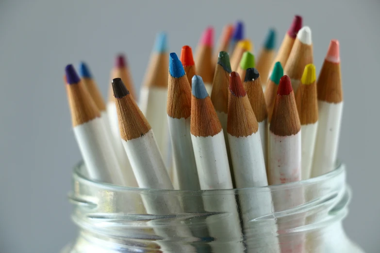 many colored pencils in the glass jar