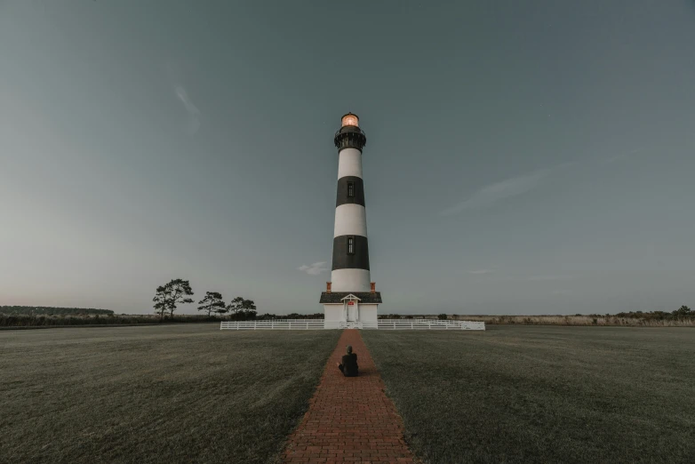 an old lighthouse at the end of a pathway