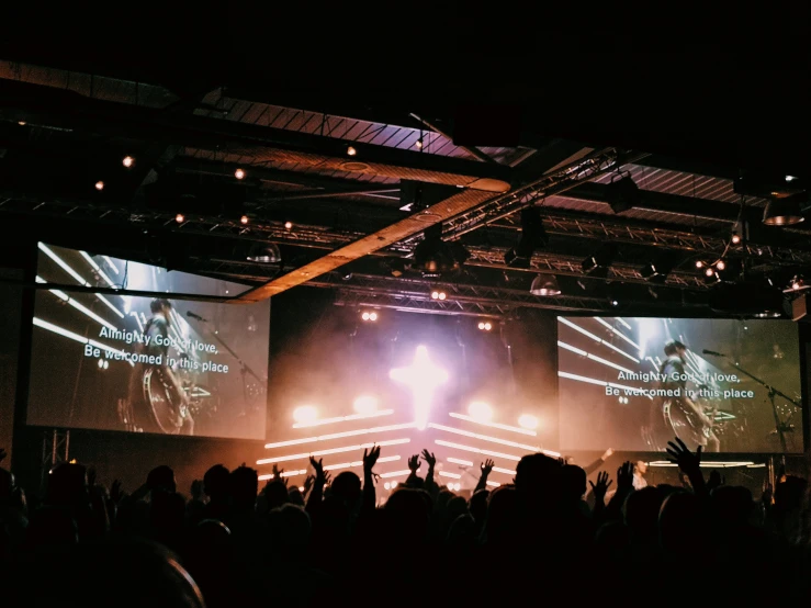 a large concert scene with lights on and people performing