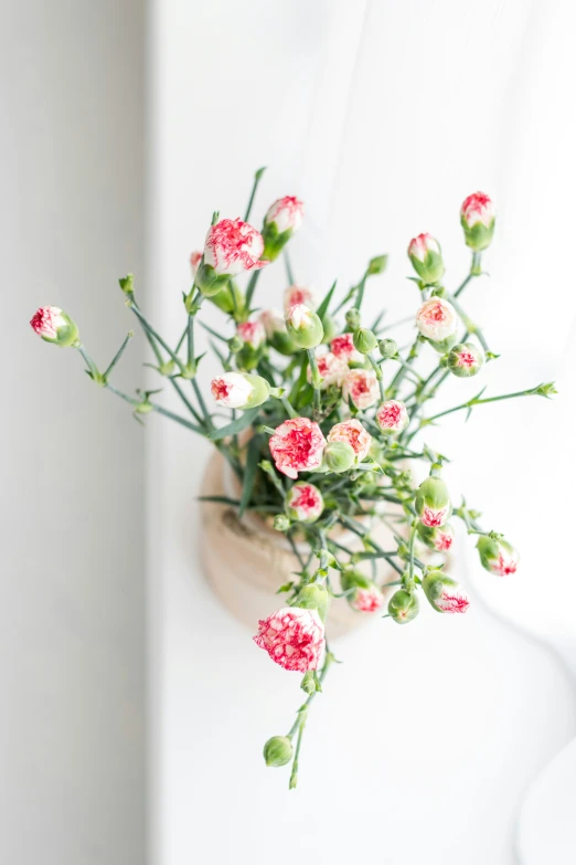 a white vase filled with pink and white flowers