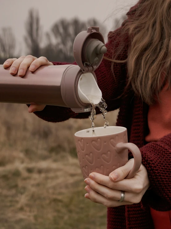 a woman holding a coffee mug in front of her face