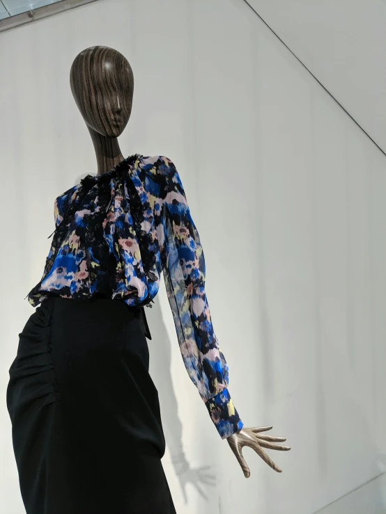 a mannequin with an open back wearing a blue blouse