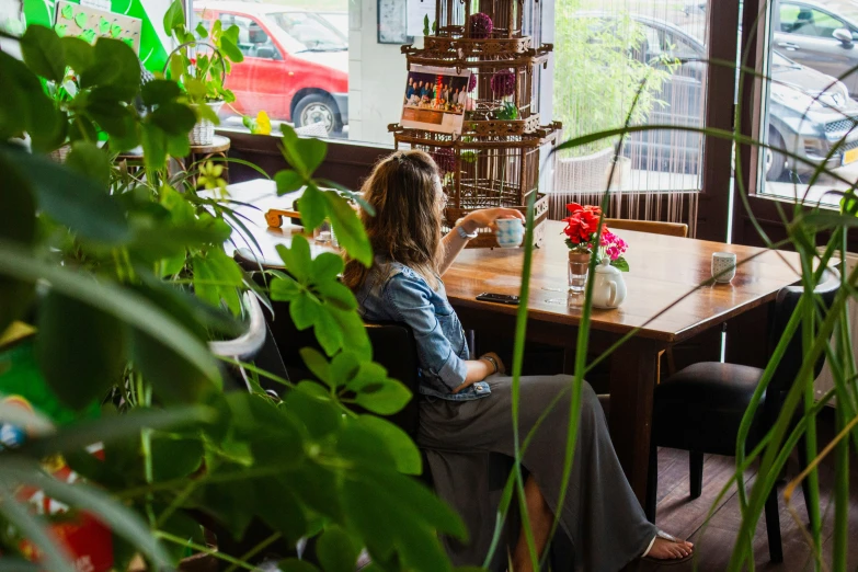 a woman sitting in a restaurant looking out a window