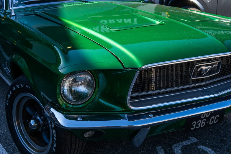 an old ford mustang with a green tint on it's hood