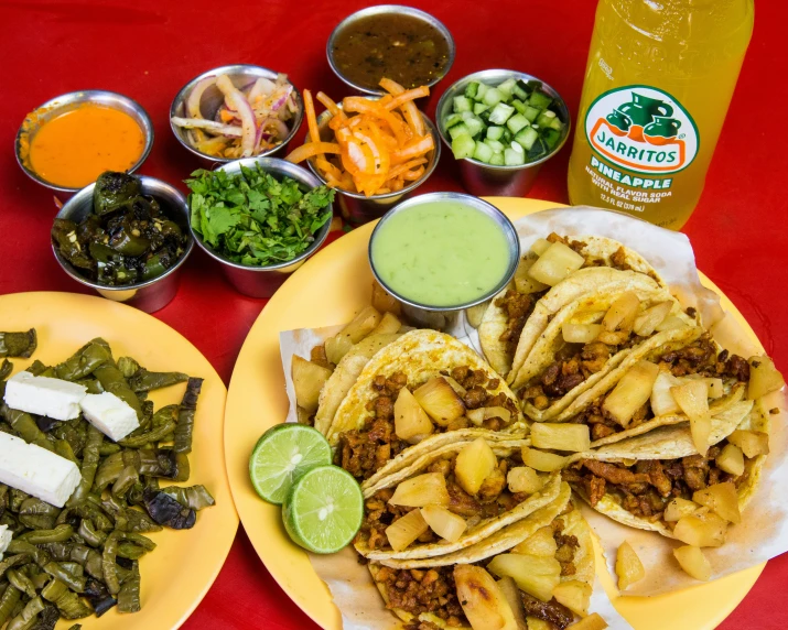 a large mexican dish is on two plates, while another is being served with tortillas