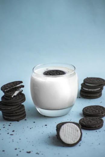 there are oreos next to a glass of milk