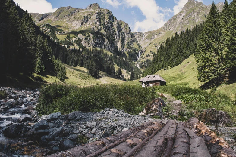 a small hut is perched high in the mountains