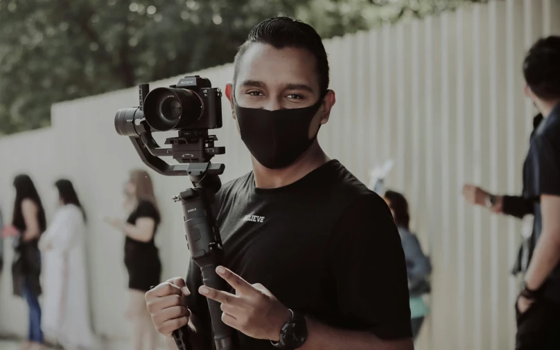 a man with a mask holding a camera