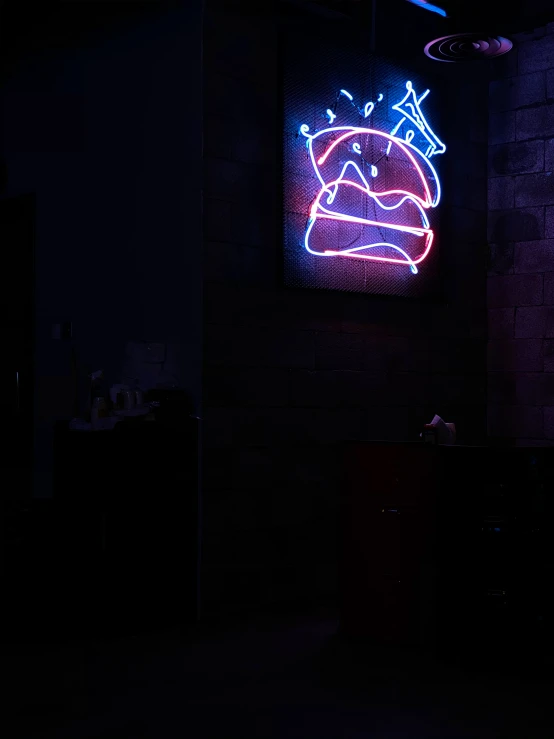 a wall with a neon sign and a small picture on it