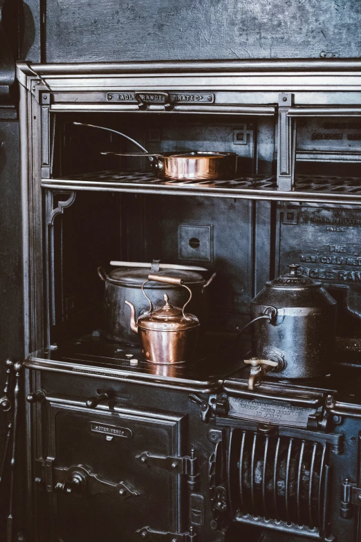 an old fashioned stove with pots on it